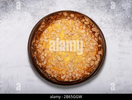 Hausgemachter Kuchen mit Hüttenkäsesuffle und Mandelflocken auf hellem rustikalem Hintergrund. Draufsicht. Kopierbereich. Stockfoto