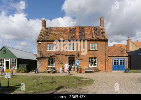 Sommerszene im Küstendorf Walberswick, Suffolk, Großbritannien; Besucher von Geschäften auf dem Green. Stockfoto