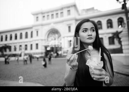 Junge schöne asiatische Touristenfrau, die Straßennahrung isst Stockfoto