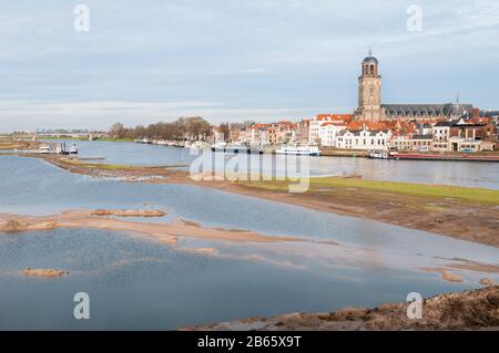 Deventer, NIEDERLANDE - 18. JANUAR 2014: Das historische Zentrum von Deventer mit der Lebuinuskirche und dem Fluss IJssel im Vordergrund. Stockfoto