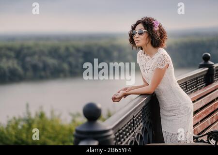 Junge afrikanische Maultier-Curly-Frau mit Sonnenbrille, die sich im Park erholt Stockfoto