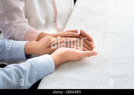 Tochter ermuntert Mutter, junge Menschen im Alter, die alte Frau Hand halten, Muttertags-Konzept Stockfoto