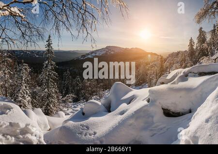 Die Winterlandschaft mit Steinglade und Wald in den Bergen Stockfoto