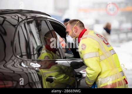 Gries Am Brenner, Österreich. März 2020. Ein Sanitäter spricht mit dem Fahrgast eines aus Italien kommenden Autos an einem Kontrollpunkt der Brenner-Autobahn A13. Österreich führt Stichprobenkontrollen für Reisende an der Grenze ein, um eine weitere Verbreitung des neuartigen Coronavirus zu verhindern. Credit: Matthias Balk / dpa / Alamy Live News Stockfoto