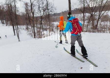 Gruppenläufer mit Rucksäcken gehen und trainieren im Winterwald Stockfoto