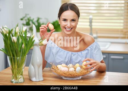 Fröhliche Erwachsene Frau in der Osterstimmung in der Küche Stockfoto