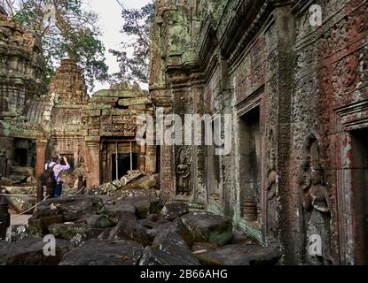 TA Prohm ist der moderne Name dessen, was ursprünglich Rajavihar hieß. Ta Prohm, erbaut im Bayon-Stil im späten 12. Jahrhundert, wurde als buddhistisches Kloster und Universität gegründet. Im Gegensatz zu den meisten renovierten Angkor Tempeln ist Ta Prohm in fast demselben Zustand geblieben, in dem er gefunden wurde - die Wurzeln und Bäume sind so zu einem Teil der Strukturen geworden, dass, wenn sie entfernt werden, die Strukturen ihre Integrität verlieren würden. Stockfoto