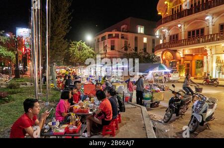 Käufer sehen sich einen Marktstand an, der bunte Kleidung an der Pub Street in der Innenstadt von Siem Reap, Kambodscha, Asien verkauft. Siem Reap ist die Hauptstadt der Provinz Siem Reap. Pub Street ist ein berühmtes Ziel für ein lebendiges Nachtleben für Touristen und Reisende, da es Restaurants und Bars spät geöffnet bleiben Stockfoto