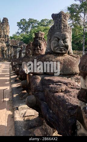 Archäologische Stätte, das Südtor von Angkor Thom führt zum Bayon-Tempel. Gesäumt von 54 Steinfiguren, die mit einer Aufführung einer berühmten Hindugeschichte beschäftigt sind, erstreckt sie sich etwa 50 Meter über einen Wassergraben. Stockfoto