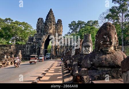 Archäologische Stätte, das Südtor von Angkor Thom führt zum Bayon-Tempel. Gesäumt von 54 Steinfiguren, die mit einer Aufführung einer berühmten Hindugeschichte beschäftigt sind, erstreckt sie sich etwa 50 Meter über einen Wassergraben. Stockfoto