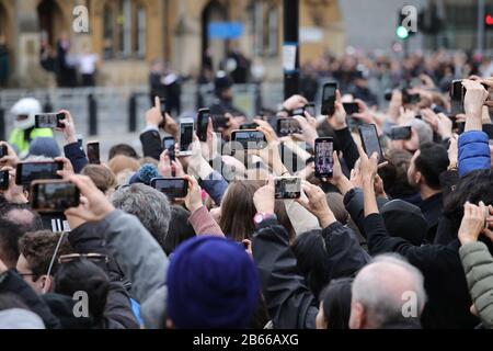 Die Leute halten ihr Handy auf, um Bilder von der Königsfamilie zu erhalten. Der Commonwealth Service in der Westminster Abbey heute, an dem Königin Elizabeth II., Prinz Karl Der Prinz von Wales, Camilla Die Herzogin von Cornwall, Prinz Wilhelm Der Herzog von Cambridge, Katharina Die Herzogin von Cambridge, Prinz Harry Der Herzog von Sussex, Meghan Markle Die Herzogin von Sussex, Prinz Edward Der Earl of Wessex, Sophie Die Gräfin von Wessex, zusammen mit Regierungschefs und Vertretern der Länder des Commonwealth. Commonwealth Service, Westminster Abbey, London, 9. März 2020. Stockfoto