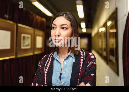 Besucherin betrachtet das Gemälde in Kunstgalerie und Denken. Das Konzept der modernen Kunst Stockfoto