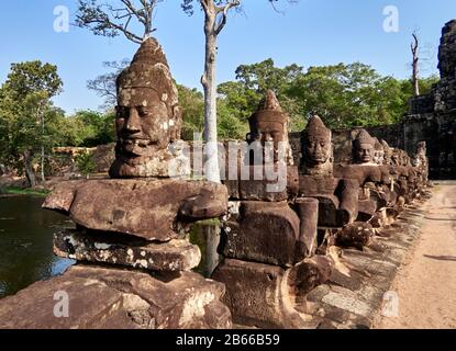 Archäologische Stätte, das Südtor von Angkor Thom führt zum Bayon-Tempel. Gesäumt von 54 Steinfiguren, die mit einer Aufführung einer berühmten Hindugeschichte beschäftigt sind, erstreckt sie sich etwa 50 Meter über einen Wassergraben. Stockfoto