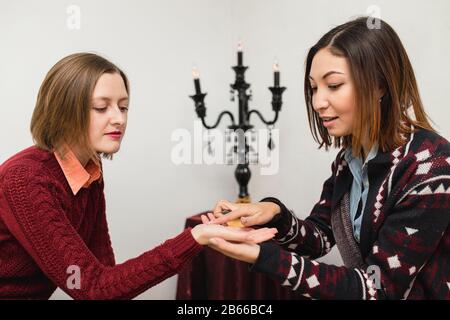 Zigeunerfrau liest die Zeilen in der Hand eines jungen Mädchens. Das Konzept von Palmistry Friend Stockfoto