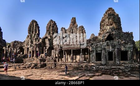 Rosafarbener Sandstein, der prächtige Bayon-Tempel, der sich in der letzten Hauptstadt des Khmer Imperiums - Angkor Thom - befindet. Seine 54 gotischen Türme sind mit 216 riesigen lächelnden Gesichtern dekoriert. Erbaut im späten 12. Oder frühen 13. Jahrhundert als offizieller Staatstempel des Königs Jayavarman VII Stockfoto