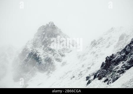 Berggipfel voller Schnee umgeben von Wolken in den Alpen. Filmfilter hinzugefügt Stockfoto