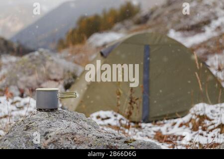 Leichter und praktischer Titan-Topf auf dem Hintergrund des Zeltes. Konzeptgerichte zum Wandern und Trekking Stockfoto