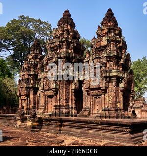 Kambodscha, im Norden von Angkor, Kambodscha. Banteay Srei (oder Banteay Srey, das heißt Zitadelle der Frauen) ist ein kambodianischer Tempel aus dem 10. Jahrhundert, der größtenteils aus rotem Sandstein erbaut wurde und dem hindu-gott Shiva gewidmet ist. Angkor war früher der Sitz des Khmer-Imperiums, das von ungefähr dem neunten Jahrhundert bis zum dreizehnten Jahrhundert florierte. Die Ruinen der Angkor Tempel gehören zum UNESCO-Weltkulturerbe. Stockfoto