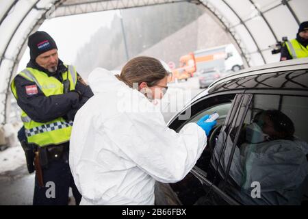 Gries Am Brenner, Österreich. März 2020. Ein Arzt führt an einem Kontrollpunkt auf der Brennerautobahn A13 Fieberkontrollen von Reisenden durch, die aus Italien kommen. Österreich führt stichprobenartige Kontrollen von Reisenden ein, die das Land an der Grenze betreten, um eine weitere Verbreitung des neuartigen Coronavirus zu verhindern. Credit: Matthias Balk / dpa / Alamy Live News Stockfoto