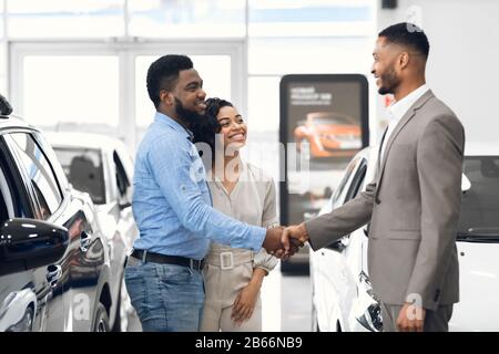 Autohändler Nach Erfolgreichem Geschäft Im Geschäft Mit Käufern In Handshake Stockfoto