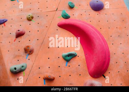 Kletterwand im modernen Fitnessstudio mit farbigen Haken Stockfoto