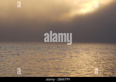 Starker Nebel, der in Drammen über dem Fjord hängt, während er sonnenbaden wird. Stockfoto