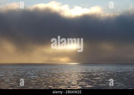 Starker Nebel, der in Drammen über dem Fjord hängt, während er sonnenbaden wird. Stockfoto