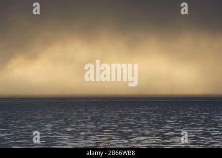 Starker Nebel, der in Drammen über dem Fjord hängt, während er sonnenbaden wird. Stockfoto