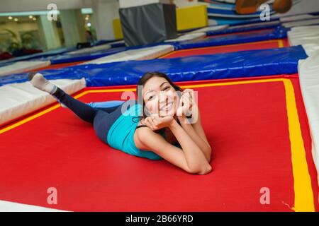 Junge Frau springt auf Trampolin und ruht in der Sporthalle Stockfoto