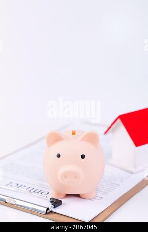 Finanzklage - Piggy Bank, wunderschönes rot-weißes Holzhausmodell auf weißem Hintergrund, spart Geld beim Kauf von Versicherungen, Nahaufnahme, Kopierplatz. Stockfoto