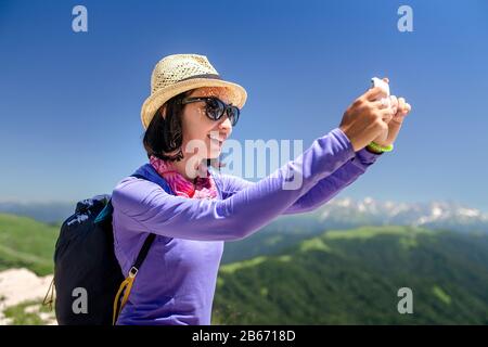 Reisender in den Bergen macht selfie auf Smartphone Stockfoto