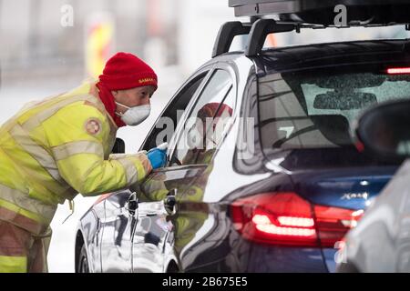 10. März 2020, Österreich, Gries Am Brenner: Ein Sanitäter spricht den Fahrer eines aus Italien kommenden Fahrzeugs an einem Kontrollpunkt der Brennerautobahn A13 an. Österreich führt stichprobenartige Kontrollen für Reisende ein, die an der Grenze in das Land einreisen, um eine weitere Verbreitung des neuartigen Coronavirus zu verhindern. Foto: Matthias Balk / dpa Stockfoto