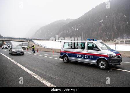 März 2020, Österreich, Gries Am Brenner: Ein Polizist beauftragt den Fahrer eines aus Italien kommenden Fahrzeugs, an einem Kontrollpunkt der Brennerautobahn A13 zu einer Fieberkontrolle zu fahren. Österreich führt stichprobenartige Kontrollen für Reisende ein, die an der Landesgrenze in das Land einreisen, um eine weitere Verbreitung des neuartigen Coronavirus zu verhindern. Foto: Matthias Balk / dpa Stockfoto