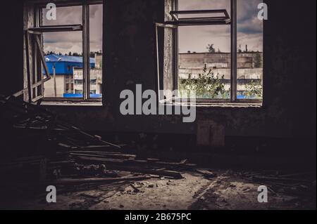 Unschärfe-Horror halloween Hintergrund. Dunkles Zimmer in einem verlassenen, zerstörten Gebäude. Licht aus einem Fenster mit zerbrochenem Glas. Stockfoto