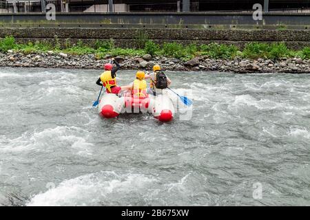 Herrenmannschaft auf einem aufblasbaren Katamaran am rauhen Fluss Stockfoto