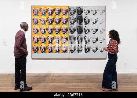 London, Großbritannien. März 2020. Die Mitarbeiter posieren neben 'Marilyn Diptych', 1962, von Andy Warhol. Vorschau von 'Andy Warhol', einer Retrospektive mit über 100 Werken eines der bekanntesten Künstler des späten 20. Jahrhunderts. Die Ausstellung läuft vom 12. März bis 6. September 2020 in Tate Modern. Kredit: Stephen Chung / Alamy Live News Stockfoto