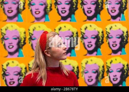 London, Großbritannien. März 2020. Ein Mitarbeiter posiert neben 'Marilyn Diptych', 1962, von Andy Warhol. Vorschau von 'Andy Warhol', einer Retrospektive mit über 100 Werken eines der bekanntesten Künstler des späten 20. Jahrhunderts. Die Ausstellung läuft vom 12. März bis 6. September 2020 in Tate Modern. Kredit: Stephen Chung / Alamy Live News Stockfoto