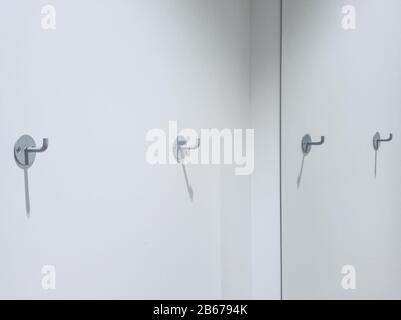 Zwei Kleiderhaken an einer weißen Wand mit Platz für Kopien Stockfoto