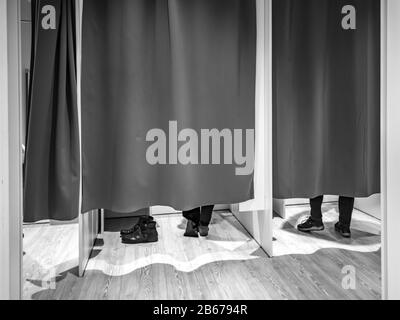 Umkleideraum mit geschlossenen Vorhängen und Füßen von zwei Kunden Stockfoto