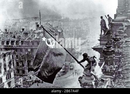 Berlin 2. Mai 1945. Roter Armeesoldat fliegt die sowjetischen Flaggen vom ruinierten Reichstag. Foto: Yevgeny Khaldei Stockfoto