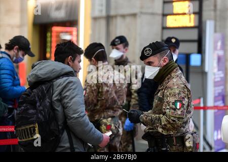 Mailand, Italien - 10. März 2020: Italienische Militärangehörige und Polizeibeamte, die Gesichtsschutzmasken tragen, überprüfen Passagiere, die den Bahnhof Stazione Centrale verlassen, da neue restriktive Maßnahmen ergriffen werden, um den Ausbruch von Coronavirus COVID-19 Credit zu verhindern: Piero Cruciatti/Alamy Live News Stockfoto