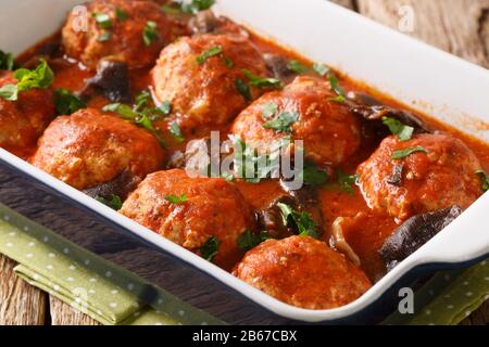 Italienische Fleischbällchen mit Wildpilzen in würziger Tomatensauce in einer Pfanne auf dem Tisch. Horizontal Stockfoto