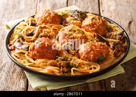 Rezept für köstliche Spaghetti mit Fleischbällchen und Pilzgravy in einem Teller auf dem Tisch. Horizontal Stockfoto