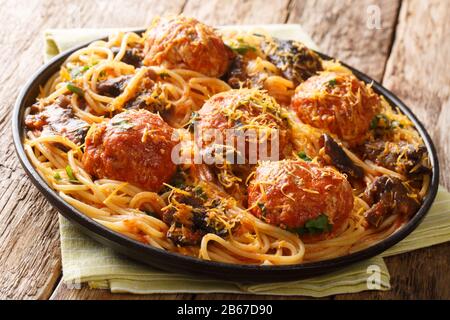 Würzige Spaghetti mit Fleischbällchen und Pilzgravie in einer Platte auf dem Tisch. Horizontal Stockfoto