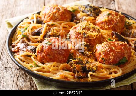 Leckere italienische Spaghetti mit Fleischbällchen und Pilzsauce in einem Teller auf dem Tisch. Horizontal Stockfoto