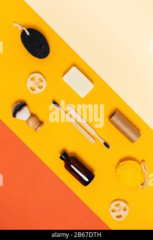 Eine Gruppe von Öko-Kosmetik-Produkten und -Werkzeugen für die Dusche, vertikales Bild mit gelbem und orangefarbenem Hintergrund. Stockfoto
