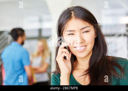 Asiatische Start-Up-Geschäftsfrau spricht im Büro auf ihrem Handy Stockfoto