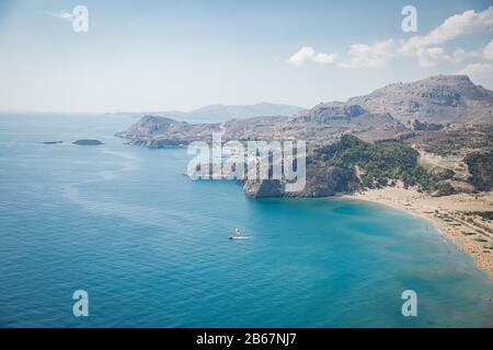 Panoramablick auf den Strand Tsampika, Berge und blaues Meer, Insel Rhodos, Griechenland. Sonniges Wetter. Stockfoto