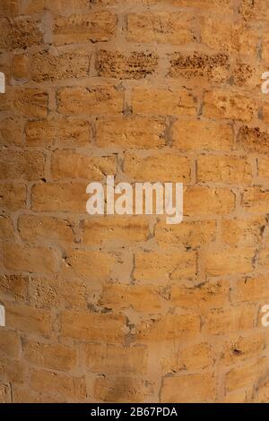 Ein Fragment einer antiken, zylindrischen Mauer aus Stein. Kreativer Vintage-Hintergrund Stockfoto