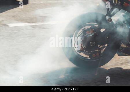 Motorradrad raucht auf Asphalt Stockfoto